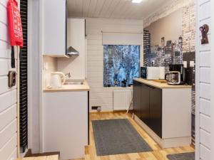 eine Küche mit weißen Schränken und einer Arbeitsplatte in der Unterkunft Holiday Home Mustalampi 3 lintukoto by Interhome in Niskala