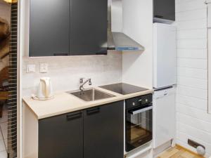 eine kleine Küche mit Spüle und Herd in der Unterkunft Holiday Home Mustalampi 3 lintukoto by Interhome in Niskala + 10 Fotos