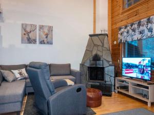 a living room with a couch chair and a television at Holiday Home Ansa by Interhome in Sirkka