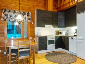 a kitchen with a wooden table and a dining room at Holiday Home Ansa by Interhome in Sirkka