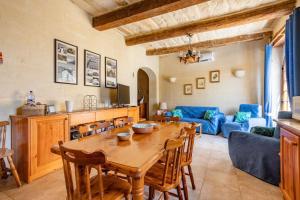 cocina y sala de estar con mesa de madera en Gozo Rustic Farmhouse with stunning views and swimming pool, en Sannat