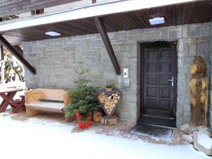 a stone building with a black door and a bench at Holiday Home Chata Labaika by Interhome in Harrachov