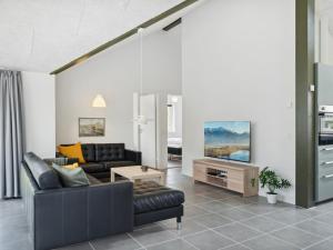 a living room with a couch and a tv at Holiday Home Human - 10-5km from the sea by Interhome in Oksbøl
