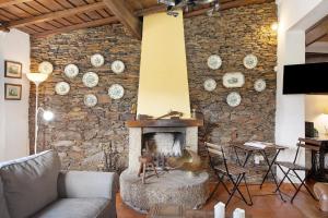 sala de estar con pared de piedra y chimenea en Azenha da Lagoa Negra, en Barqueiros