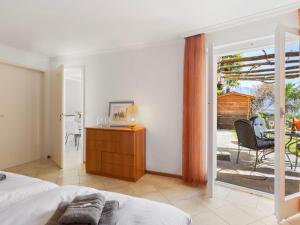 1 dormitorio con 1 cama y puerta corredera de cristal en Apartment Vista Isole di Brissago by Interhome, en Ronco sopra Ascona