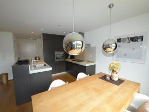 a kitchen and dining room with a wooden table at Apartment Uehlinger Züger by Interhome in Valbella