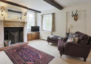 a living room with a couch and a fireplace at Mill Cottage in Ufford