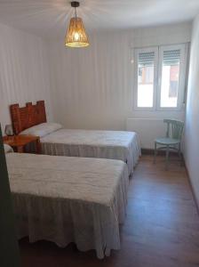 una camera con tre letti, una lampada e una sedia di Agradable casa antigua reformada con patio a Espejón Altre 13 foto