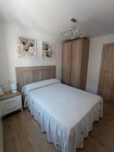 una camera da letto con due letti e un lampadario di Agradable casa antigua reformada con patio a Espejón