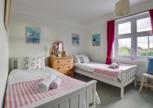 a bedroom with two beds and a window at Millers Cottage in Woodbridge