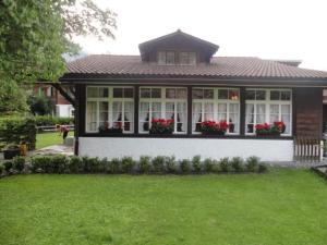 a house with red flowers in the windows at Apartment Chalet Stöckli by Interhome in Kandersteg