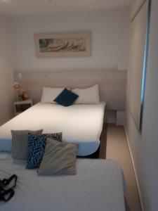two beds in a small room with two beds sidx sidx sidx at Loft Porto Marina Itacuruçá in Mangaratiba