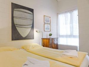 a bedroom with a bed and a painting on the wall at Apartment Im Gruebi Apt-5 by Interhome in Wengen