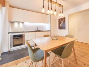 a kitchen and dining room with a wooden table and chairs at Apartment Les Mélèzes by Interhome in Les Collons