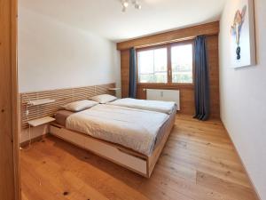 Schlafzimmer mit einem Bett und einem Fenster in der Unterkunft Apartment Les Mélèzes by Interhome in Les Collons