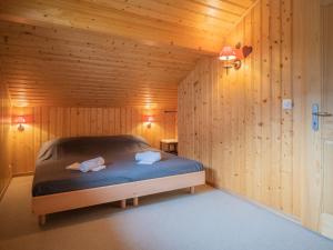 een slaapkamer met een bed in een houten kamer bij Chalet Le Coprin by Interhome in Ovronnaz