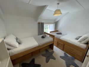 two beds in a room with stars on the floor at The Brewhouse Boscastle Harbour in Boscastle