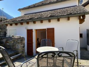 eine Terrasse mit Stühlen und einem Tisch vor einem Haus in der Unterkunft Apartment Casa della Posta-2 by Interhome in Rossa