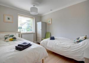a bedroom with two beds and a window at Number Eight in Westleton