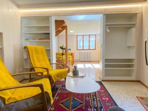 sala de estar con sillas amarillas y mesa en Apartment Casa della Posta-1 by Interhome, en Rossa
