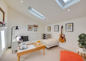 ein Wohnzimmer mit einem weißen Sofa und einem Tisch in der Unterkunft Oak Barn Annexe in Trimley Heath