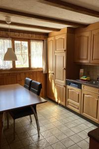 a kitchen with wooden cabinets and a table and chairs at Apartment Wildbach by Interhome in Adelboden