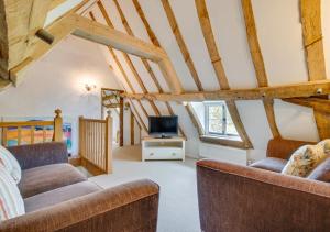 sala de estar con 2 sofás y TV en Old Black Horse Farm, en Finningham