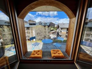 een raam met uitzicht op een tafel en stoelen bij Apartment Ferme de Sandra E0 by Interhome in Nendaz