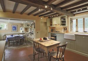 a kitchen with a wooden table and chairs and a kitchen with a dining room at Old Farm in Walberswick