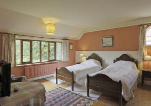 a bedroom with two beds and a tv in it at Old Farm in Walberswick