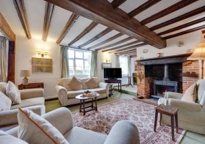 a living room with couches and a fireplace at Old Brewery House in Orford