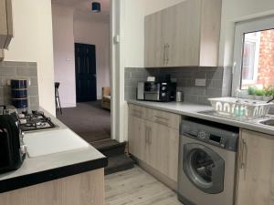 a kitchen with a washing machine and a stove at Rawling - Welcoming 3 bed apartment with free Wifi and Free Parking in Gateshead