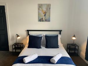 a bedroom with a bed with blue and white pillows at Rawling - Welcoming 3 bed apartment with free Wifi and Free Parking in Gateshead