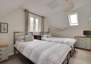 1 dormitorio con 2 camas y ventana en Owl Lodge en Ufford