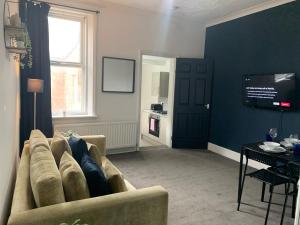 a living room with a couch and a tv at Rawling - Welcoming 3 bed apartment with free Wifi and Free Parking in Gateshead