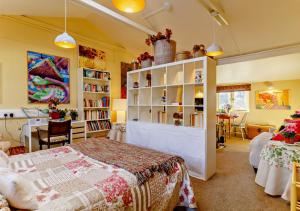 a bedroom with a bed and a book shelf at Owls Nest in Stradbroke