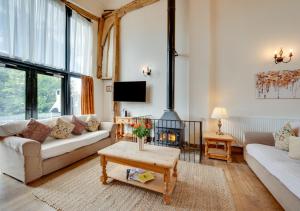 a living room with a couch and a fireplace at Owls End at Wattisham Hall in Wattisham
