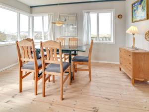 jadalnia ze stołem, krzesłami i oknami w obiekcie Holiday Home Sohvi - 450m from the sea in Western Jutland by Interhome w mieście Lakolk