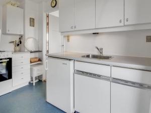 una cocina con armarios blancos y fregadero en Holiday Home Sohvi - 450m from the sea in Western Jutland by Interhome, en Lakolk
