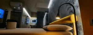 a bedroom with a bed with a yellow head board at Il Vicolo Luxury Rooms in Nettuno