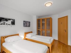 two twin beds in a room with white walls at Chalet Chalet Pflaume by Interhome in Bad Gastein