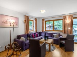 a living room with a purple couch and a table at Chalet Chalet Pflaume by Interhome in Bad Gastein