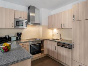 a kitchen with wooden cabinets and stainless steel appliances at Chalet Chalet Pflaume by Interhome in Bad Gastein