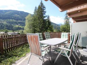 a table and chairs on a patio with mountains in the background at Chalet Chalet Pflaume by Interhome in Bad Gastein