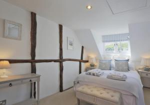 a bedroom with a large bed and two windows at Oyster Cottage in Southwold