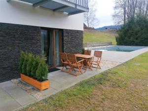 Un patio con una mesa y sillas al lado de una casa. en Studio Vista 1 by Interhome, en Rokytnice nad Jizerou