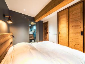 sypialnia z dużym białym łóżkiem i drewnianymi drzwiami w obiekcie Appartement rénové 4 pièces, proche pistes, terrasse, WIFI, Tignes le Lac - FR-1-502-462 w mieście Tignes
