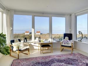 a living room with a table and chairs and large windows at Holiday Home Aranja - 300m to the inlet by Interhome in Løgstør