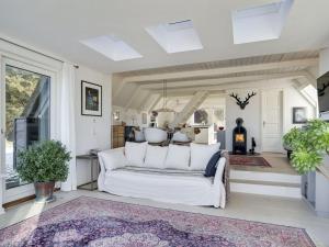 a living room with a white couch and a fireplace at Holiday Home Aranja - 300m to the inlet by Interhome in Løgstør