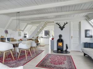 a living room with a table and a fireplace at Holiday Home Aranja - 300m to the inlet by Interhome in Løgstør